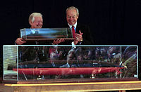 Carter (left) with a replica of the USS Jimmy Carter with Secretary of the Navy John H. Dalton (right) at a naming ceremony, April 28, 1998