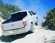 2006 Ridgeline RTL with all-terrain tires climbing steep hill off-road