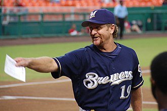 A man in a navy baseball uniform with "Brewers" across the chest and a navy cap with an "M" on the center