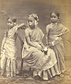 Image 13A Tamil Hindu girl (center) in 1870 wearing a half-saree, flowers and jewelry from her Ritu Kala samskara rite of passage (from Samskara (rite of passage))
