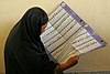 An Afghan woman examines the ballot during the 2005 election.