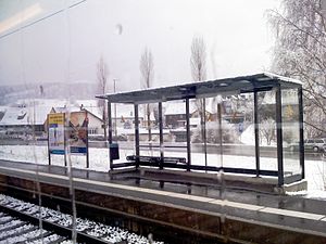 Snow falls on platform with a shelter