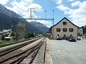 Two-story building with gabled roof next to platforms and tracks