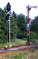 Old semaphore and new Ks signal, both able to show "Proceed with 50 km/h" and "Stop"; new signal may also show Zs1 and Zs6 (see also footnote 1)