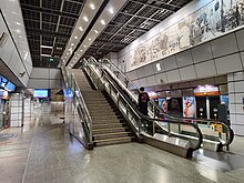 Platform level of Clarke Quay station, with escalators and stairs leading up from the platform level to the concourse