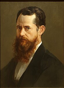 A head and shoulders portrait of a middle aged man, with a brown beard, facing to the left