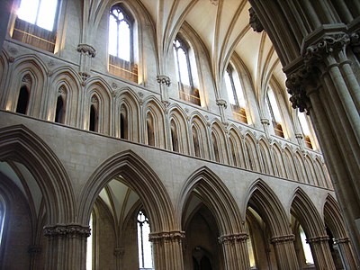 The three levels of the nave (1192–1230) of Wells Cathedral, the first in England to use pointed arches exclusively in the ceiling vaults, the windows of the clerestory and arcades of the triforium, and the arcades on the ground floor.