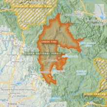 The footprint of the Creek Fire is shown in orange, and is shaped roughly like a crescent arc, with several protrusions, between Yosemite National Park to the north and Kings Canyon National Park to the south. A finger of the fire reaches out toward Mammoth Lakes, and another toward Lake Thomas A Edison. Fresno lies in the map's southwest corner.