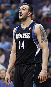 Nikola Peković, bearded, in a black Timberwolves jersey with blue and white trim