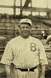 A large, smiling man in old-style baseball uniform