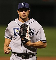 A baseball player wearing a gray jersey and navy cap