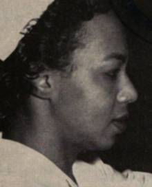 A Black woman wearing a nurse's cap, photographed in profile