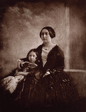 Victoria cuddling her daughter next to her