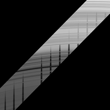 Cassini image mosaic of the unlit side of the outer C Ring (bottom) and inner B Ring (top) near Saturn's equinox, showing multiple views of the shadow of Mimas. The shadow is attenuated by the denser B ring. The Maxwell Gap is below center.