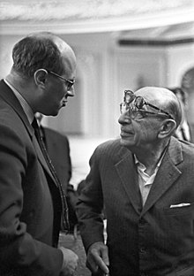 An elderly Stravinsky wearing two pairs of glasses shaking hands with Rostropovich