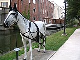 Canal boat exhibit at Memorial Park. Display features a life-sized metal horse tethered to a restored canal boat on the Miami-Erie Canal.