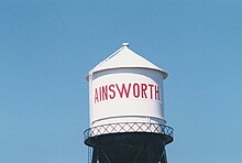 Water Tower painted white with "Ainworth" in large red letters