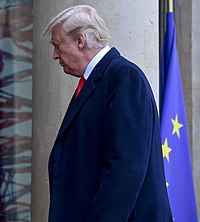 Donald Trump walks up steps, head down
