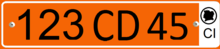 Plate with a single row of black alphanumeric characters on an orange background, and a white bar on the right side containing the black letters CI at the bottom, and a black silhouette of the Ivory Coast inside a black circle at the top.