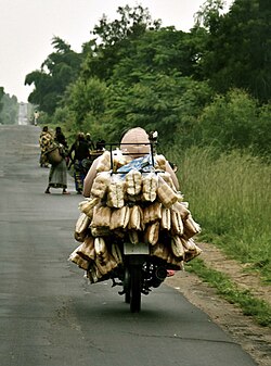 Motorcyclist carries a load in Sange, March 2023