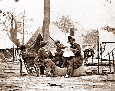 Brady (center, wearing straw hat), with General Ambrose Burnside (reading newspaper), taken in May 1864