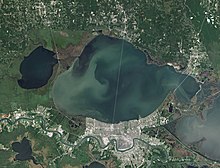 Satellite view of a large lake, with a city to the south and a smaller lake to the west