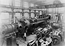 Under assembly c.1890, half of one of the two 10,000 hp engines completed for Deptford Power Station at Hick, Hargreaves and Co.[107][108][109][110] A travelling crane and hoist above.