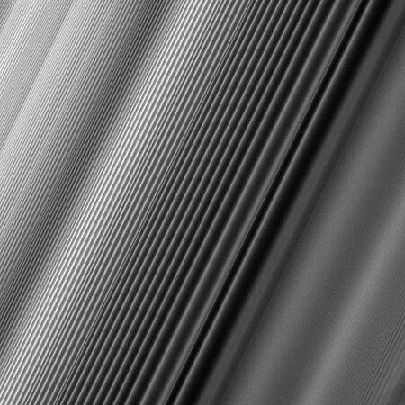 A spiral density wave in Saturn's inner B Ring which forms at a 2:1 orbital resonance with Janus. The wavelength decreases as the wave propagates away from the resonance, so the apparent foreshortening in the image is illusory.[g]
