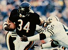 Walter Payton carrying a football and giving a stiff arm to another player on the New Orleans Saints.