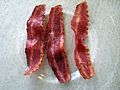 Three strips of cooked turkey bacon