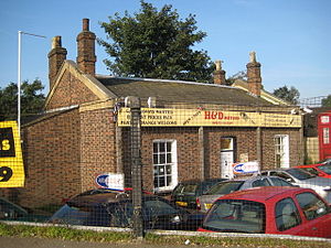 small red brick ticket office used as a car sales office