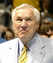 A man wearing a grey jacket and a yellow tie with blue polka dots