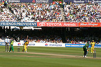 Lee bowling to a Pakistani batsman. Two other players are also seen.