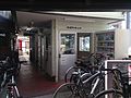 Station waiting room. The ticket window is down the narrow corridor. Note the area in the foreground is for the parking of bicycles.