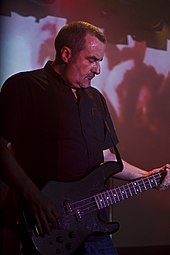 B. C. Green playing bass in a red haze