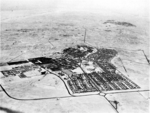 A historic photograph of a settlement in a desert from above