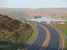 Picture of a motorway with a lake and moorland beyond it