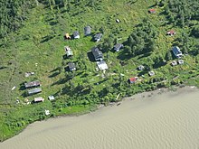 Scattered buildings along the shore of the Mackenzie River.