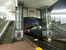 Two elevators and stairs leading up from underground station platforms