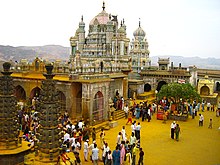 Ornate temple exterior, with many people outside
