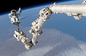 Astronaut Stephen K. Robinson, STS-114 mission specialist, anchored to a foot restraint on the International Space Station’s Canadarm2, participates in the mission’s third session of extravehicular activity (EVA). The blackness of space and Earth’s horizon form the backdrop for the image (3 August 2005).