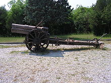 an artillery piece with no gun shield standing on gravel
