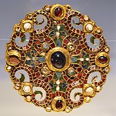 The Dorestad Brooch, c. 800, found in the Netherlands. Gold, pearls, with cloisonné almandine, enamel, and glass.