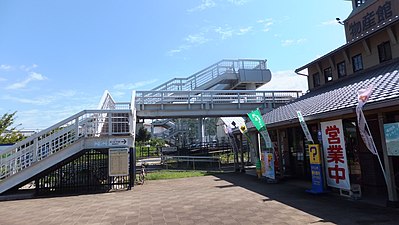 Station west entrance with the footbridge and entry to the level crossing. To the right is a shop for local products and also the kan'i itaku agent. The sign with the arrow says "JR tickets on sale (inside shop)".