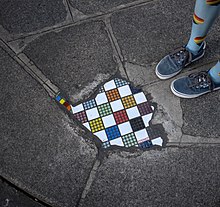 A mosaic on a sidewalk by Ememem