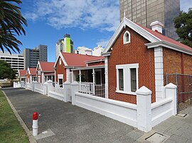 Red brick cottages with white fences in front