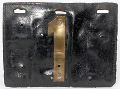 Black leather automobile license tag with a brass number on the center front. The first automobile license plate in Minnesota, 1903.