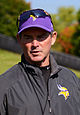 Mike Zimmer wearing a cap and sunglasses on top of his head