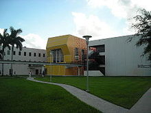 A gray building with a bright yellow entrance