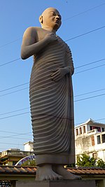 Statue of monk with one shoulder uncovered